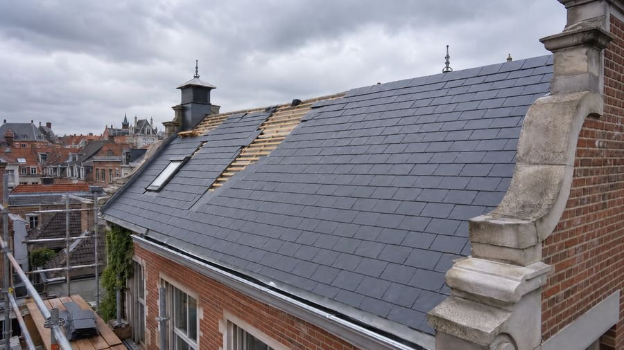 Couverture en ardoise avec voliges apparentes en cours de pose à Lavérune
